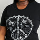 Woman modeling graphic print black tee with graphic tee with white ink - Peace sign with flowers and butterflies.